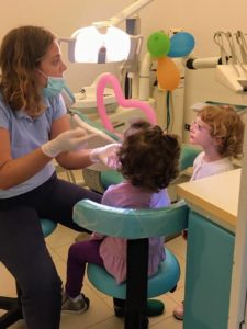 ortodontista dentista che fa la prima visita ai bambini