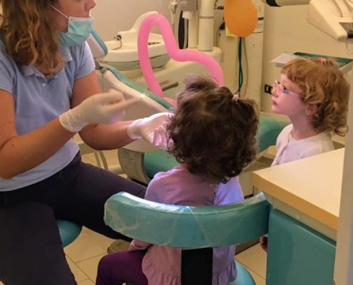 ortodontista dentista che fa la prima visita ai bambini