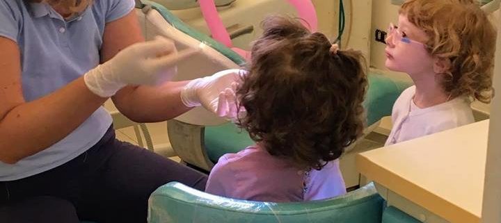 ortodontista dentista che fa la prima visita ai bambini